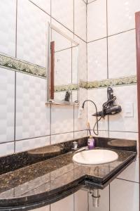 y baño con lavabo y espejo. en Apto 15 min das Aguas Termais em Araxa MG, en Araxá