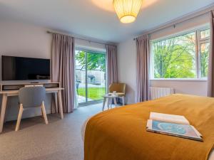 a bedroom with a bed and a desk and a television at 2 Bed in St. Mellion 87713 in St. Mellion