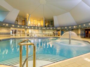 a large indoor swimming pool with a fountain at 2 Bed in St. Mellion 87713 in St. Mellion