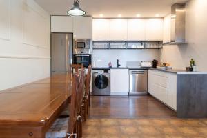 a kitchen with white cabinets and a wooden counter top at PRADOS DE VELARTA in Cerler