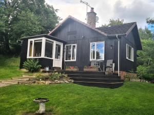 a black tiny house with a yard at 2 Bed in Blair Atholl 87927 in Bridge of Tilt