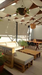 een kamer met 2 bedden, een tafel en een plafond bij Moodhu Villa - Cozy Apart w/ Amazing Terrace in Leiria