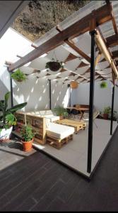 une pergola avec des lits et des plantes en pot sur une terrasse dans l'établissement Moodhu Villa - Cozy Apart w/ Amazing Terrace, à Leiria