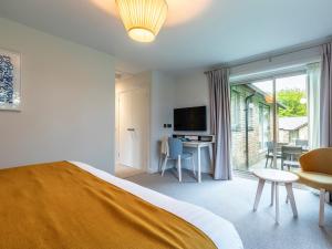 a bedroom with a bed and a desk and a television at 2 Bed in St. Mellion 87714 in St Mellion