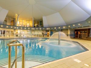 a large indoor pool with a fountain in a building at 2 Bed in St. Mellion 87714 in St Mellion