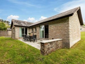 a brick house with a patio and a table at 2 Bed in St. Mellion 87714 in St Mellion