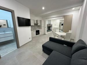 a living room with a black couch and a table at SOLUZIONE CASA Pietra Ligure SEA HOUSE in Pietra Ligure