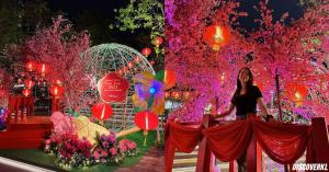 a woman standing in front of a display of flowers at Plaza Arkadia Desa Parkcity by KLhomesweet in Kuala Lumpur