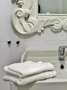 een badkamer met een witte handdoek op een wastafel bij Il Bumbunin Esclusivo monolocale nel cuore di Asti in Asti