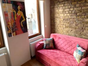 a pink couch in a room with a brick wall at Istanberry - Dream Apartments in Istanbul