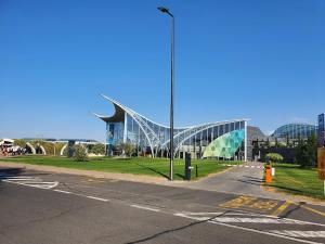 un gran edificio de cristal con una carretera delante de él en BioLocalia House Oltenia en Baloteşti