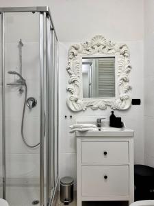 Baño blanco con lavabo y espejo en Il Bumbunin Esclusivo monolocale nel cuore di Asti en Asti