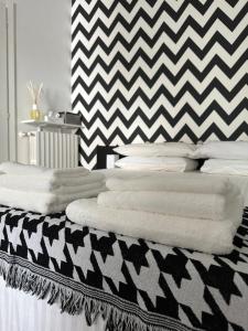 uma cama com toalhas pretas e brancas em Il Bumbunin Esclusivo monolocale nel cuore di Asti em Asti