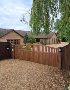 a wooden fence in front of a house at Boardman's Lodge in Peterborough