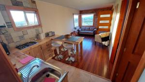 a kitchen with a sink and a table in a room at Antü Küyen Patagónica in Puerto Natales