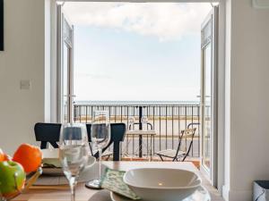 una sala da pranzo con balcone affacciato sull'oceano. di 4 Bed in Whitley Bay 87396 a Whitley Bay
