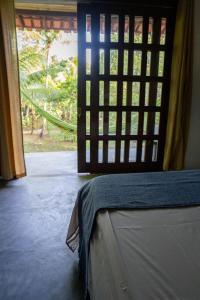 een kamer met een bed en een deur met een raam bij Chô Chuá in Cayru