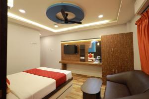 a bedroom with a bed and a desk with a mirror at Hotel Jeyam in Kanyakumari