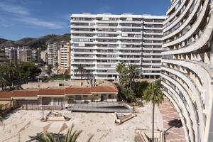 un gran edificio blanco junto a una playa y un edificio en Florazar 2, Vi-5-B, en Cullera