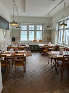 ein Esszimmer mit Holztischen und Fenstern in der Unterkunft Hotel National in Wattwil + 30 Fotos