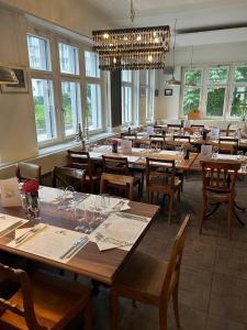 ein Esszimmer mit Tischen und Stühlen und einem Kronleuchter in der Unterkunft Hotel National in Wattwil