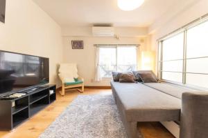 a living room with a large bed and a flat screen tv at Apartment in Akihabara Station 3 minutes away, near Tokyo Staフリ in Tokyo