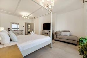 ドバイにあるJbr Sea View Captivating 4-Bed Apartment in Dubaiの白いベッドルーム(ベッド1台、ソファ付)