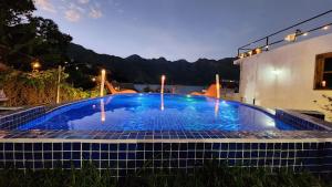 a large blue swimming pool in front of a building at NEW YORK by luxury atitlan in San Pedro La Laguna