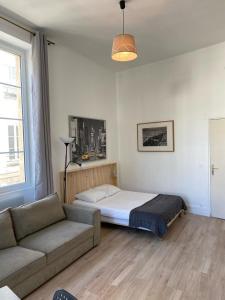 a bedroom with a bed and a couch in it at Studio Grands Boulevards in Paris