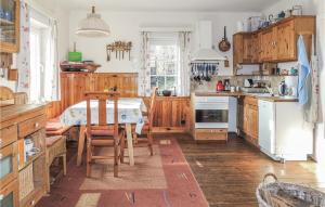 a kitchen with wooden cabinets and a table with a dining room at Gorgeous Home In Weissenstein With Kitchen in Fresach