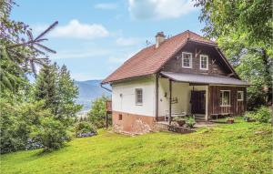 una pequeña casa en una colina con césped verde en Ferienhaus In Weissenstein en Fresach