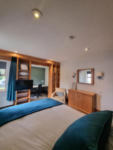 um quarto com uma cama grande e uma secretária. em Brennan Court Guest Accommodation em Limerick