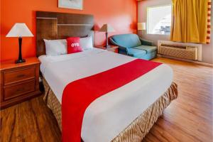 a hotel room with a large bed and a chair at Hotel Europa Ridgecrest in Ridgecrest