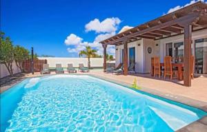 einen Pool mit Terrasse und ein Haus in der Unterkunft Villa Luna in Yaiza