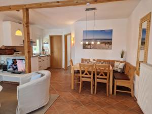 a kitchen and living room with a table and chairs at Appartement Kaminzauber in Boltenhagen