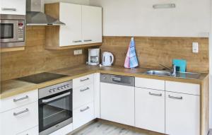 a kitchen with white cabinets and a sink at Lovely Apartment In Reith Im Alpbachtal With House A Mountain View in Brixlegg