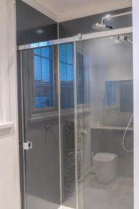 a bathroom with a toilet and a glass shower door at Town centre property convenient for the fells in Keswick