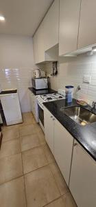 una cocina con fregadero y estufa horno superior en 8 Depto de un dormitorio cochera, en Rosario