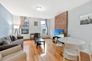 a living room with a couch and a table at Urban 1BR Close to PATH Train 15min to NYC in Hoboken