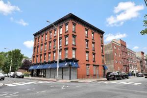 a large red brick building on a city street at Urban 1BR Close to PATH Train 15min to NYC in Hoboken