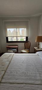 Un dormitorio con una cama grande y una ventana. en 8 Depto de un dormitorio cochera, en Rosario