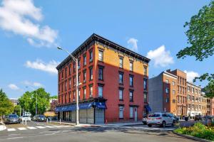 a large red brick building on a city street at Bright and Charming 1BR 15min to NYC in Hoboken