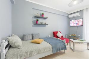 ein Schlafzimmer mit einem Bett und einem roten Stuhl in der Unterkunft Thanasis Family Apartment in Athen