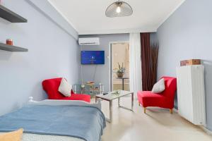 Schlafzimmer mit zwei roten Stühlen und einem Bett in der Unterkunft Thanasis Family Apartment in Athen