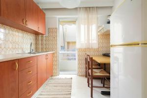 eine Küche mit Holzschränken, einem Tisch und einem Kühlschrank in der Unterkunft Thanasis Family Apartment in Athen