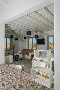 a living room with a couch and a tv at Vesper Jewel Luxury Villas in Mykonos in Tourlos