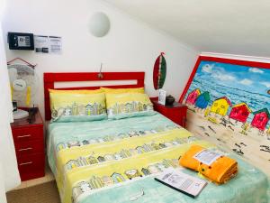 a bedroom with a bed with a painting on the wall at Cape Capsules in Muizenberg