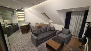 sala de estar con sofá, mesa y cocina en Sunny Mountain Apartment - Zlatibor, Serbia - SPA & WELLNESS CENTER en Zlatibor
