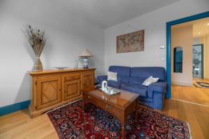 a living room with a blue couch and a coffee table at Le Darcet - Appartement Calme et lumineux in Vichy