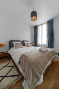 a bedroom with a large bed with a laptop on it at Le Darcet - Appartement Calme et lumineux in Vichy